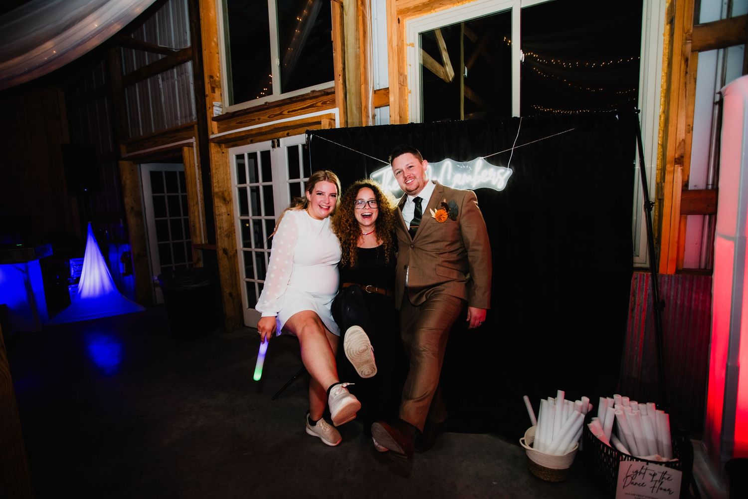 Party group enjoying themselves in a rustic wooden venue with colorful lighting.