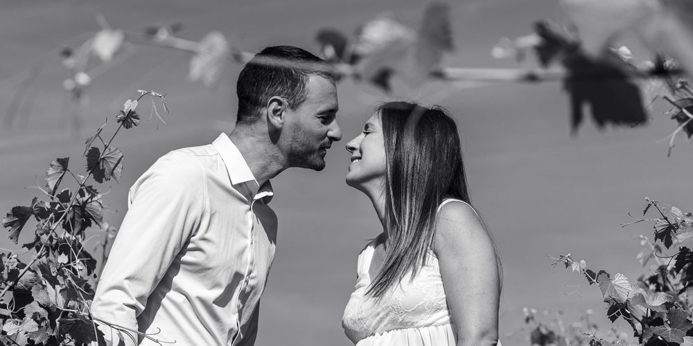 Couple de futurs parents en noir et blanc lors d’une séance photo grossesse dans les vignes