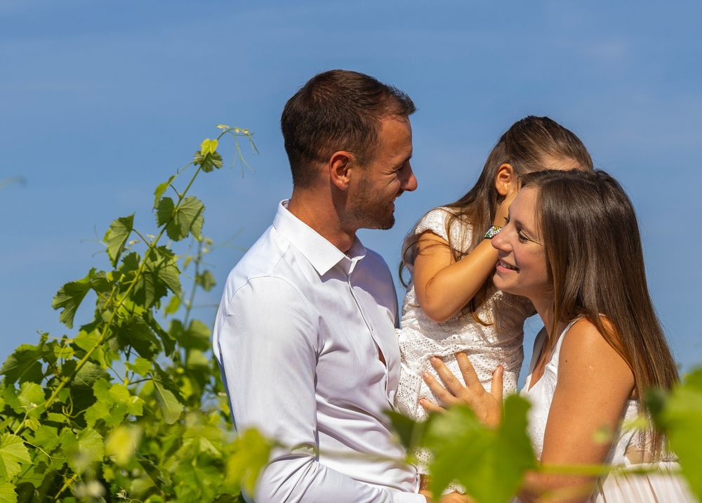 Couple de futurs parents marchant dans les vignes pendant une séance photo maternité dans le Var