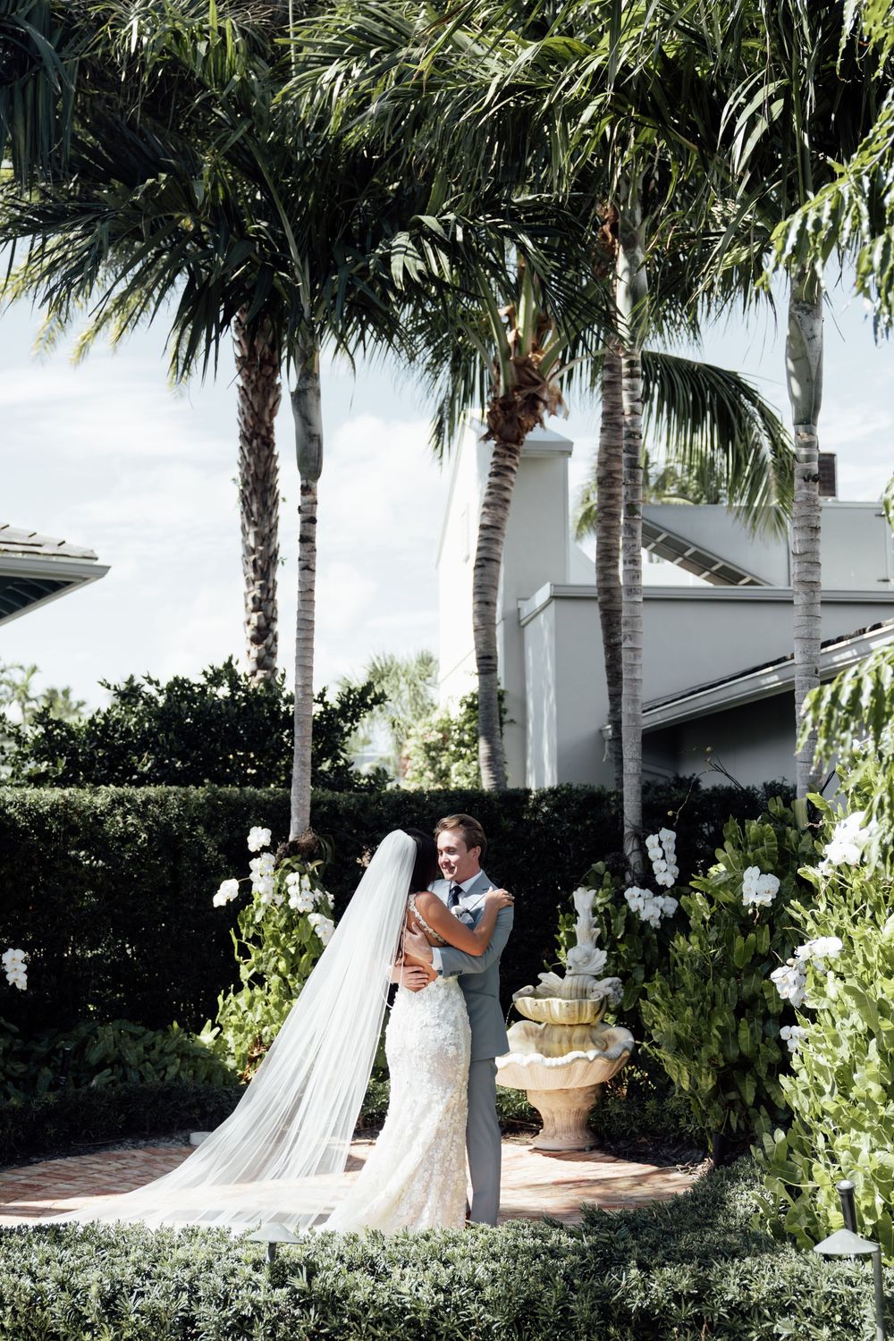 A romantic outdoor garden setting with palm trees and elegant landscaping at a wedding venue.