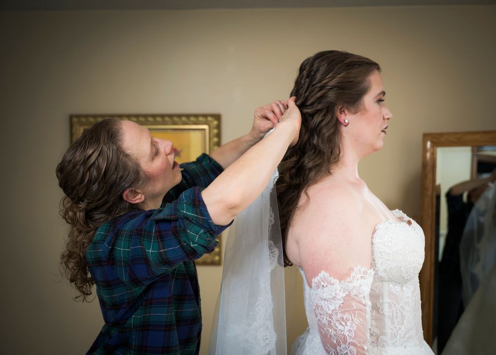 Sequence of photos showing a bride getting ready with her dress being buttoned up in a warm-lit room.