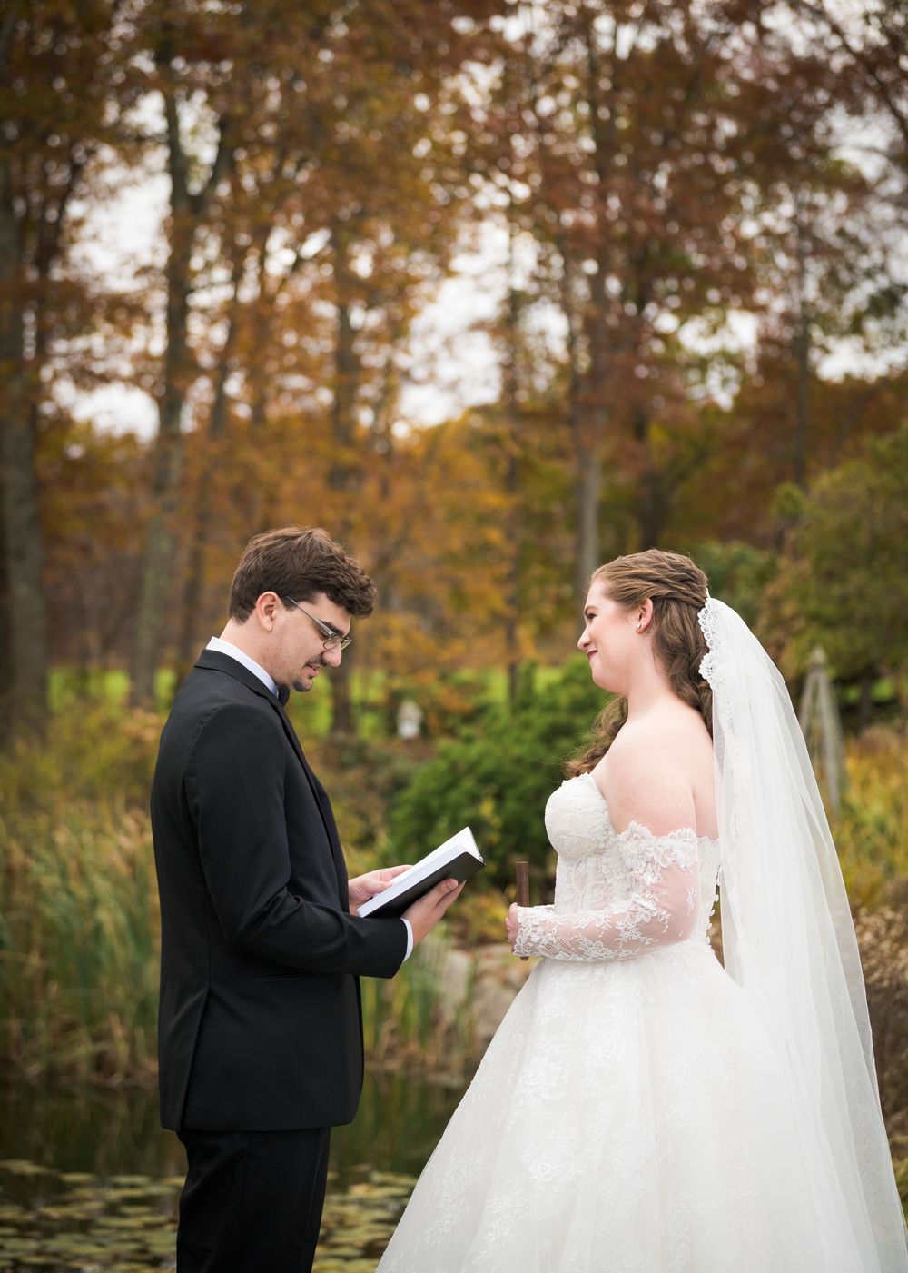 A couple exchanges private vows during their first look in a scenic autumn setting.
