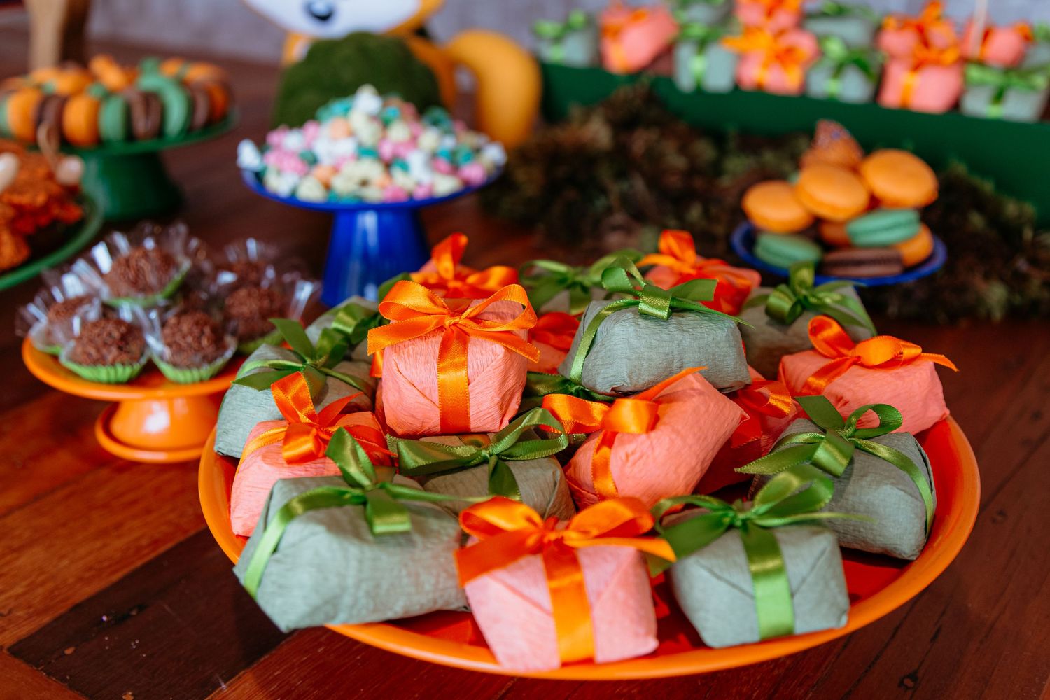 Salmon nigiri sushi arranged on white plates with garnishes of orange tobiko and green leaves.