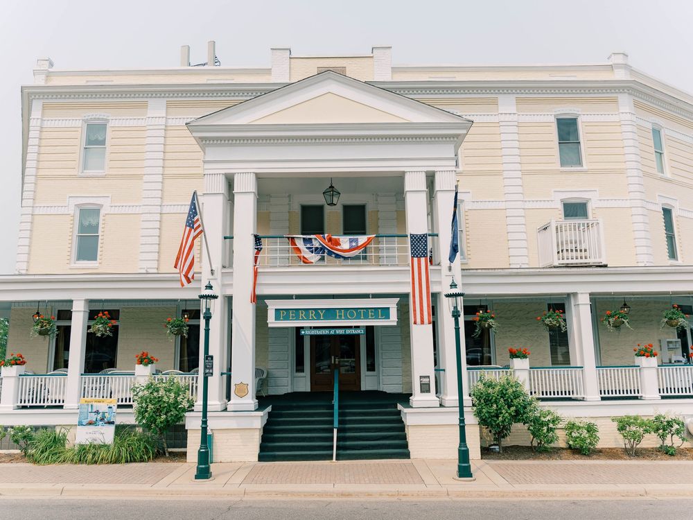 Exterior view of a classic white colonial-style building with pillars and green accents.