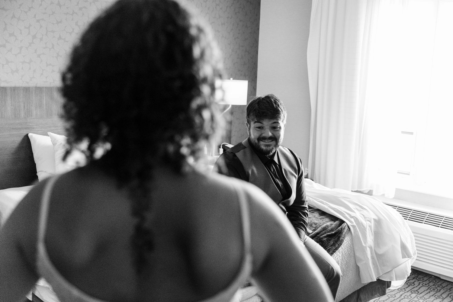 Intimate black and white portrait series showing couple in tender moments against white window light.