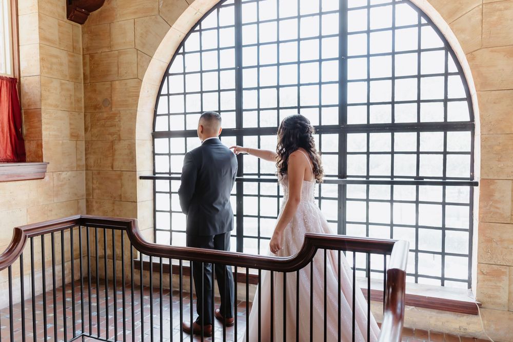Medieval castle dining room with long wooden tables and stone architecture viewed through curved archways.