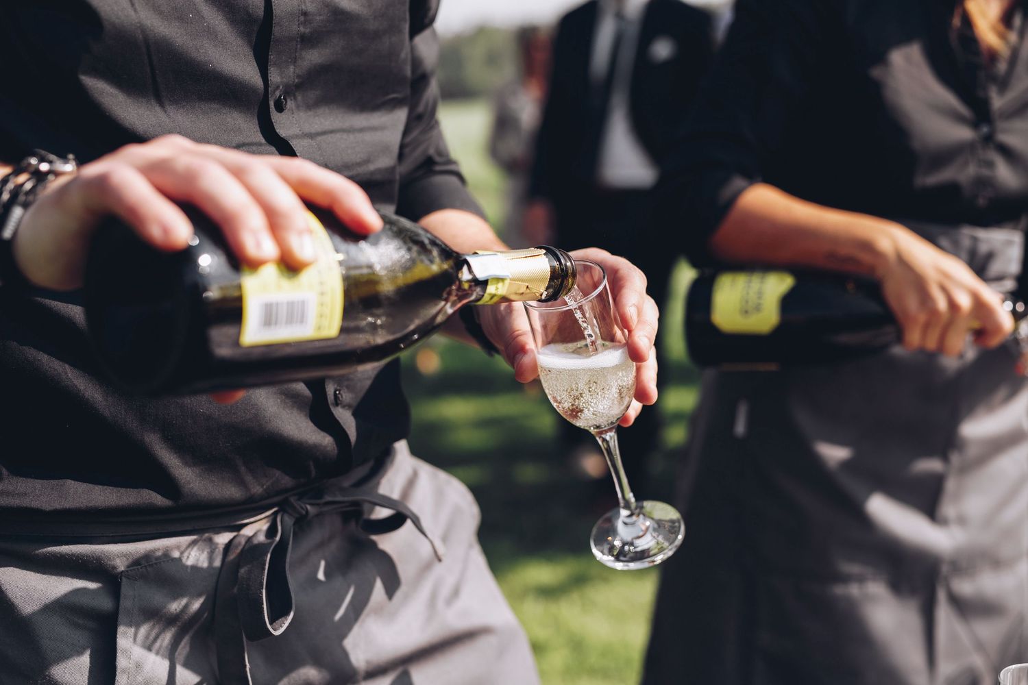 Champagne serveras i ett glas utomhus