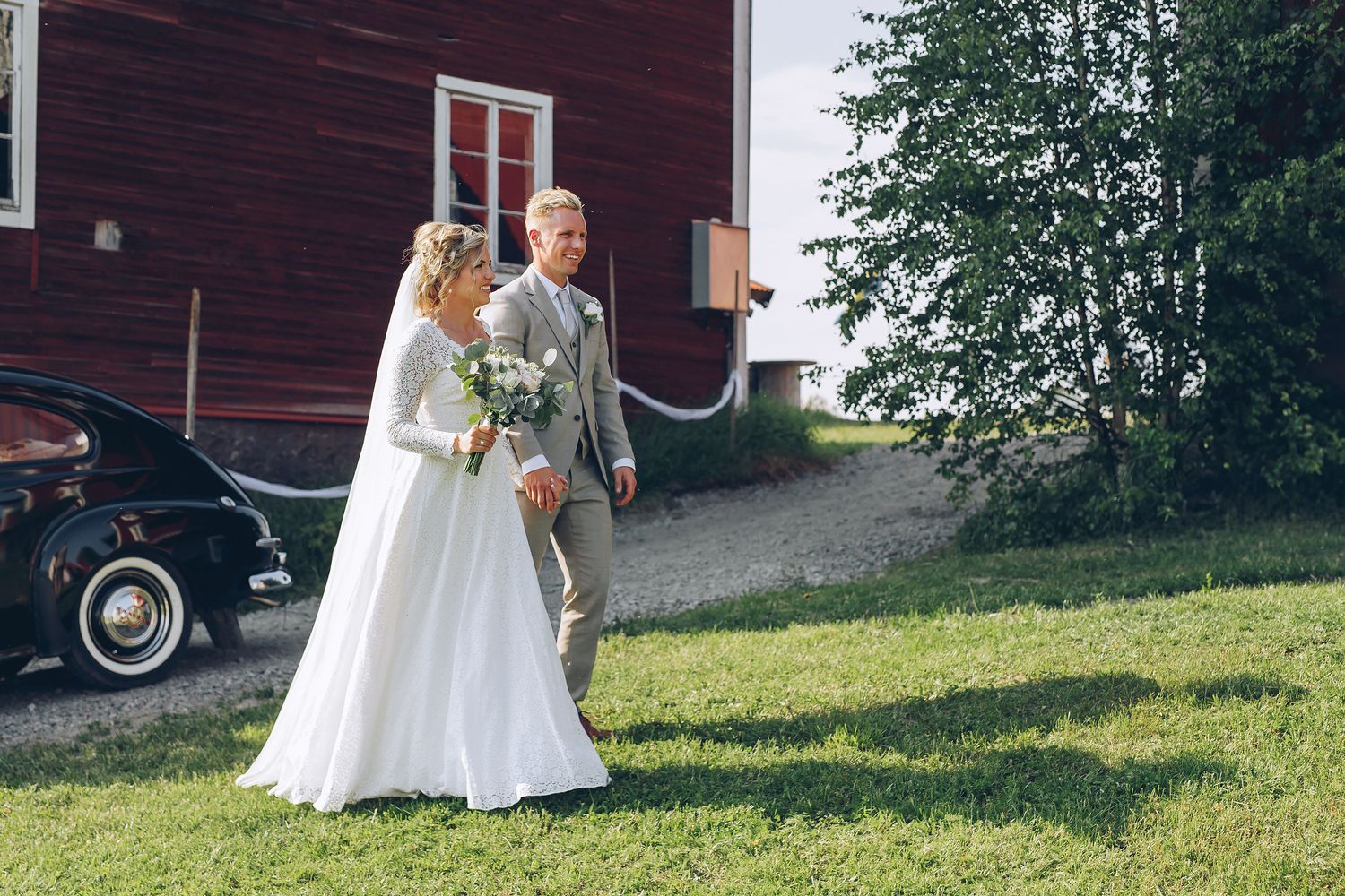 Brud och brudgum anländer glada till minglet på deras bröllop