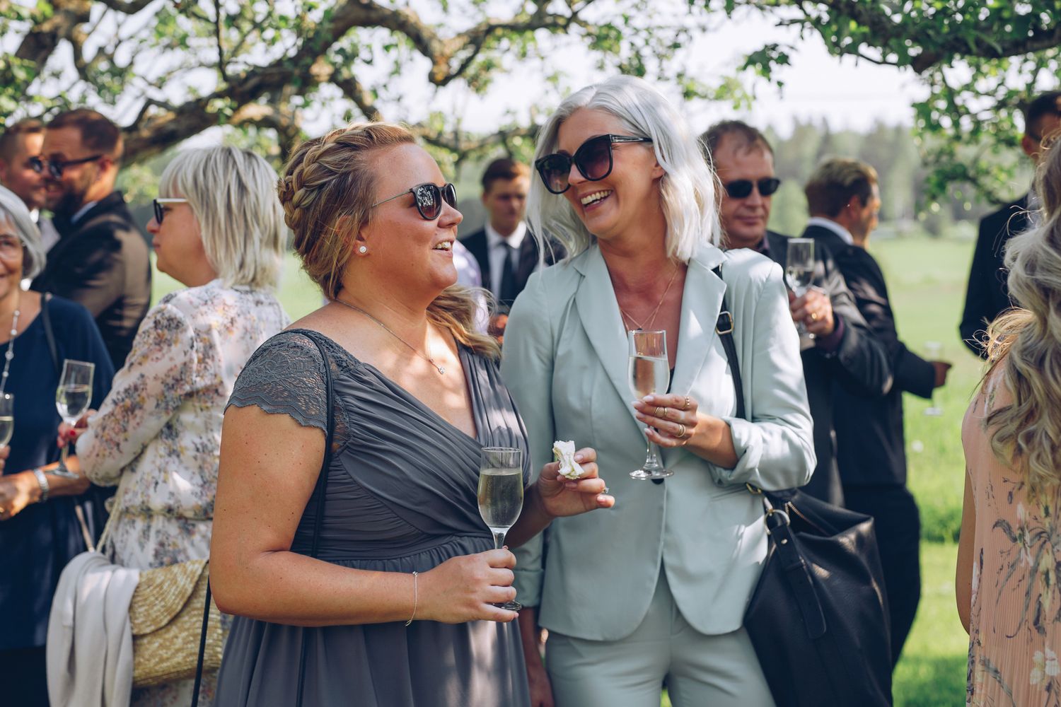 Glada gäster som minglar på bröllop utomhus