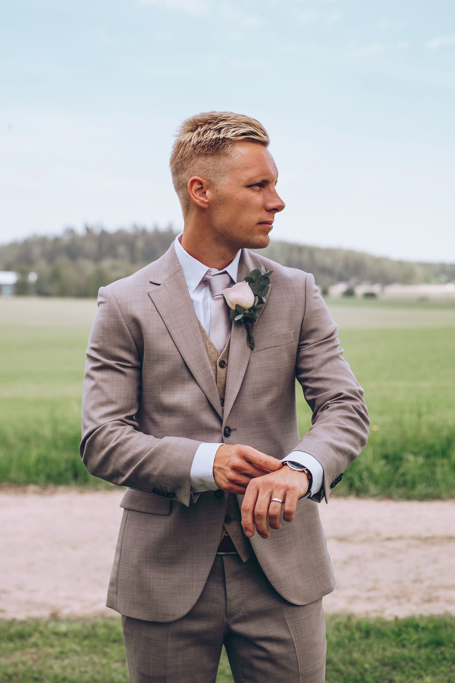 Avslappnat porträttfoto av en brudgum med ett eftertänksamt uttryck