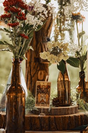 Rustic amber glass bottles with wildflowers and baby's breath create charming wedding centerpieces.
