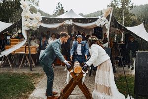 Wedding reception setup with musicians performing under white tent decorations.