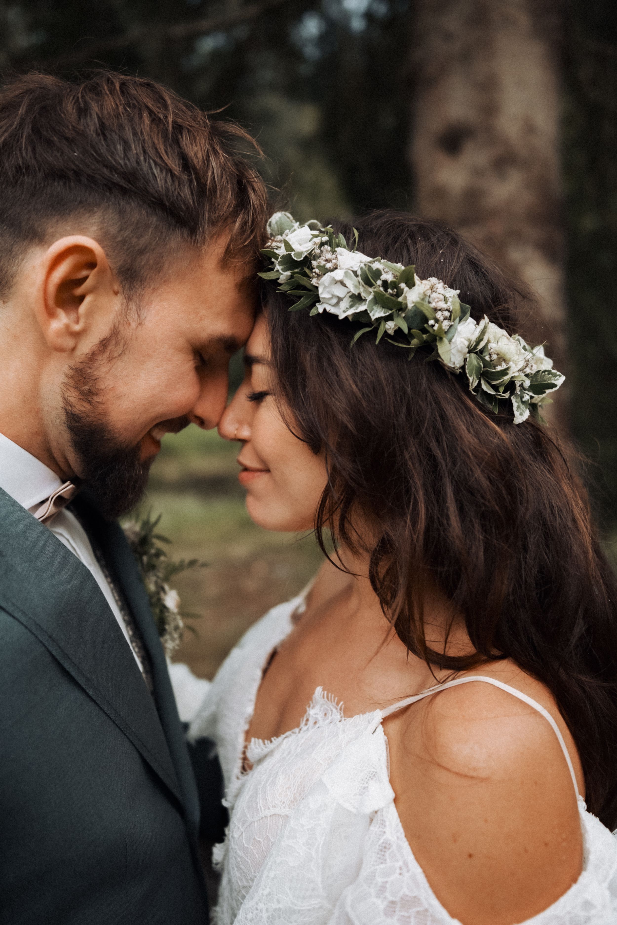 Intimate wedding portraits captured in a natural outdoor setting with soft lighting.