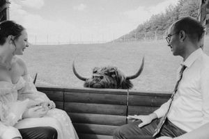 Two people sitting outdoors on brown leather seating in casual conversation.