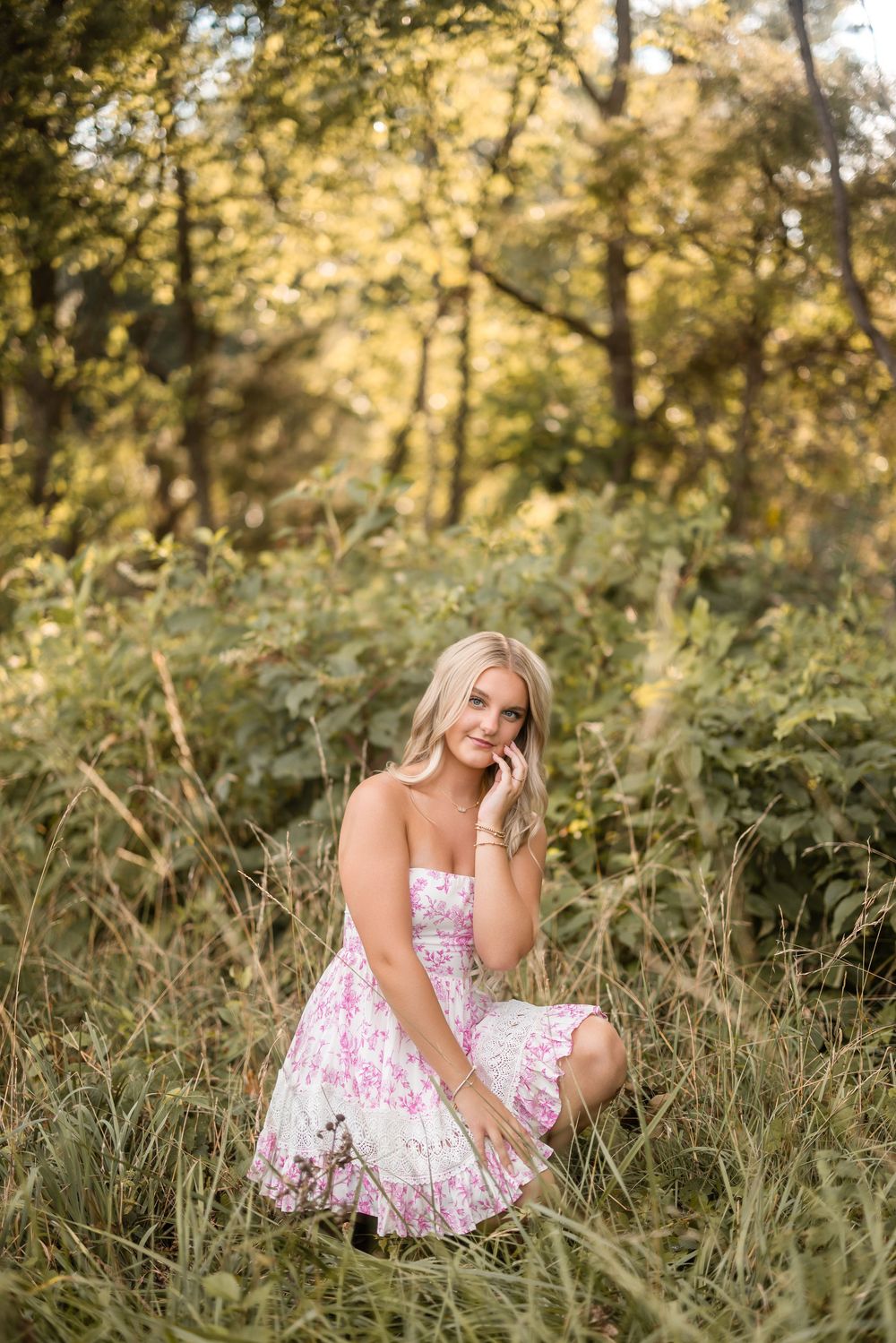 A floral summer dress catches golden light in a dreamy meadow setting during sunset.