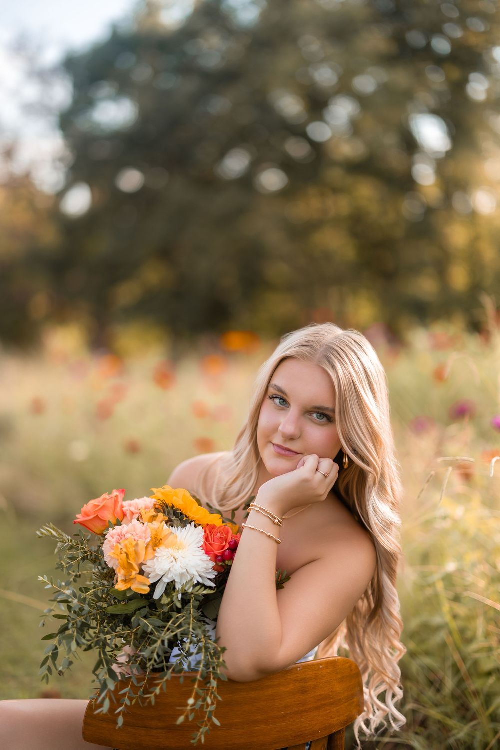 A dreamy portrait with fall flowers and wooden decor in soft natural lighting.