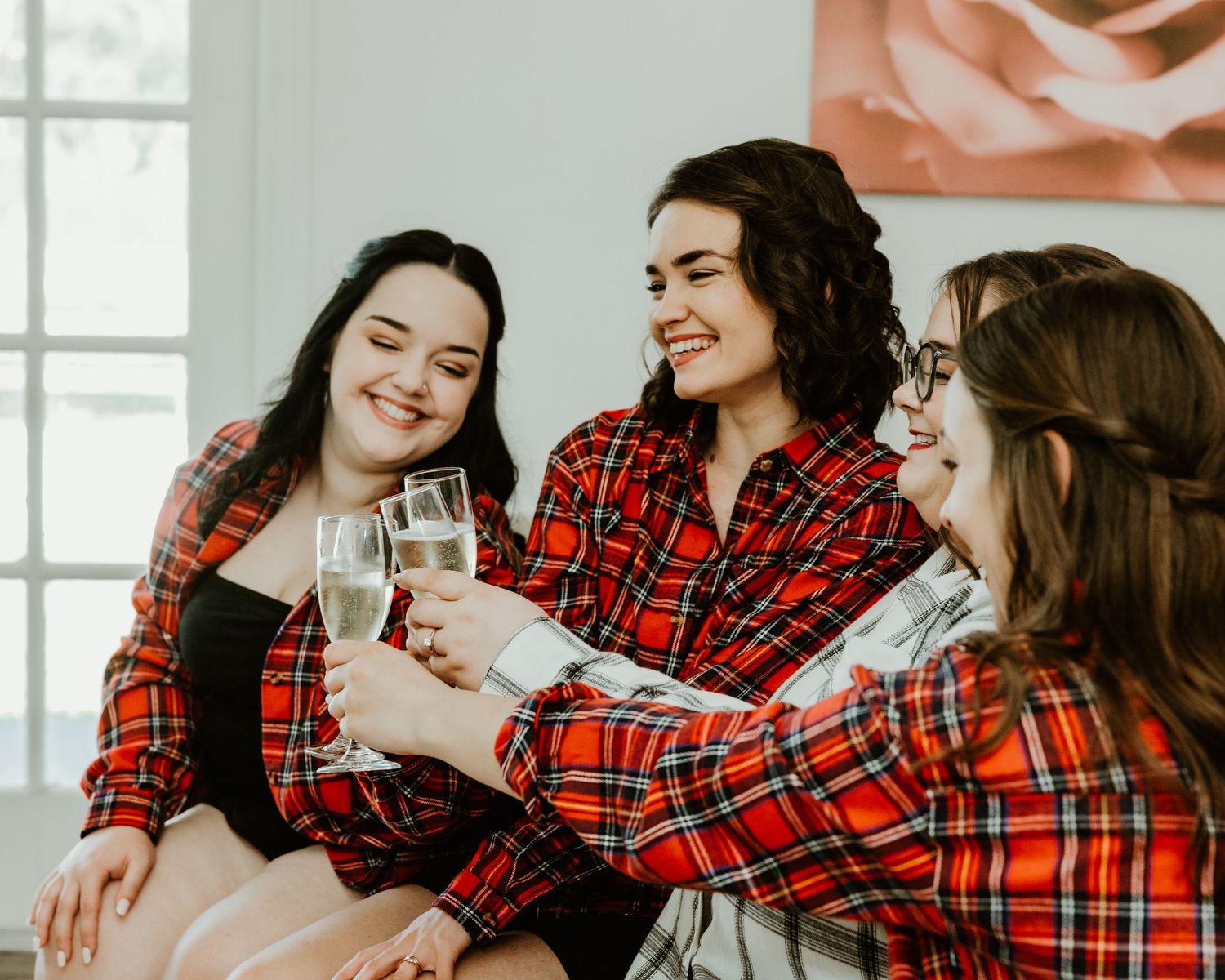 A group wearing matching red plaid pajamas shares warm holiday moments together at home. Florida Wedding Photographer. Getting ready photos