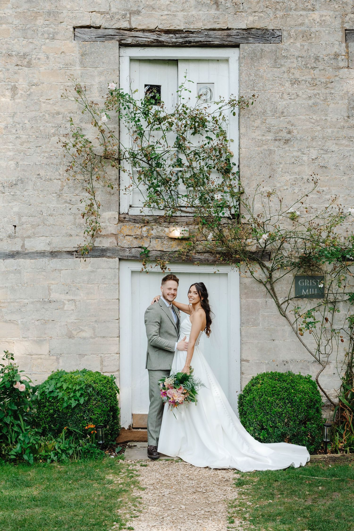 Owlpen Manor Weddings Photographer Zara Davis Photography Cotswolds Uley Cheltenham Gloucestershire bride and groom in front of mill house