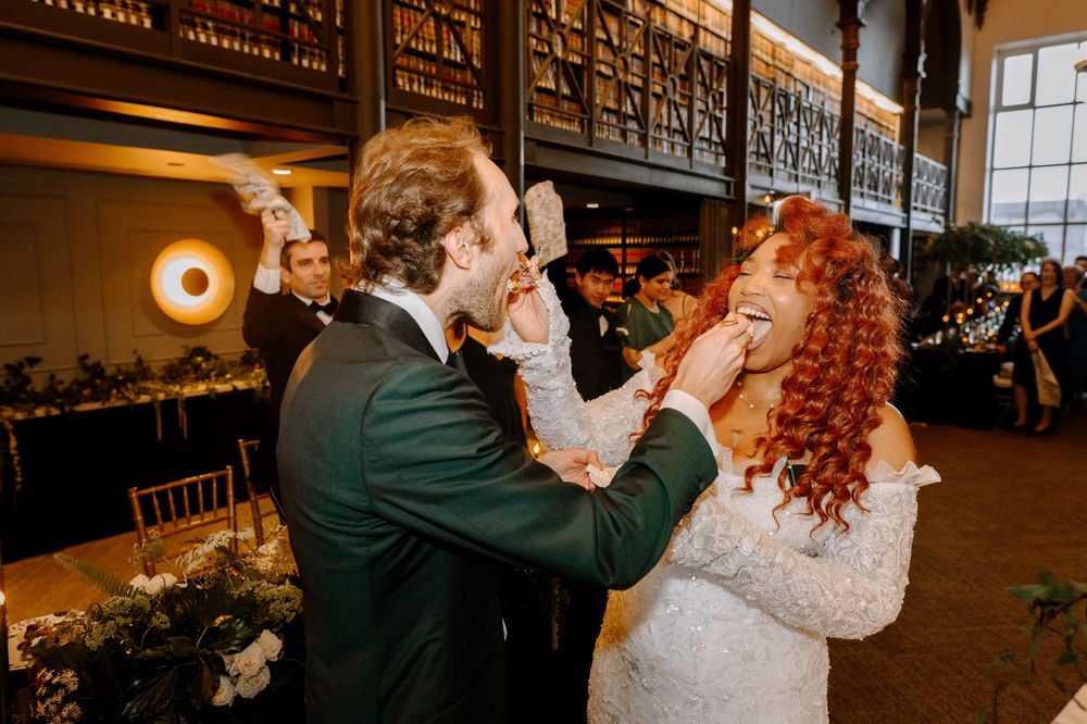 Dancing couples twirl across a warm-lit library ballroom during a wedding celebration.