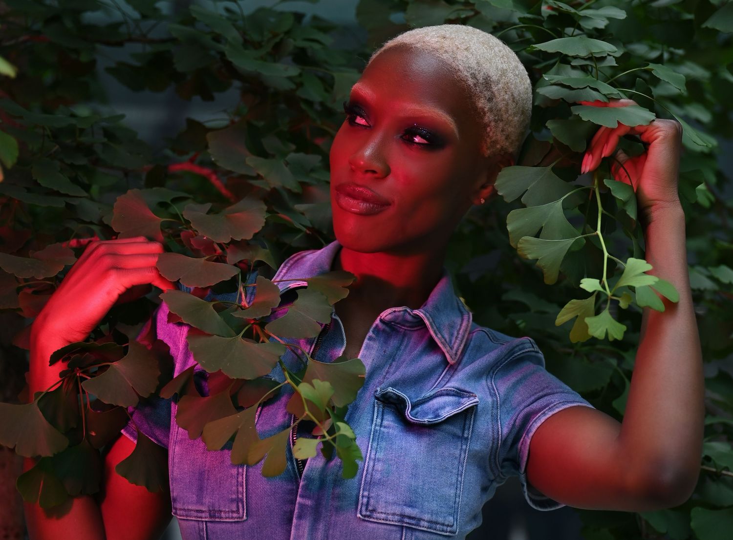 Artistic portrait series in red lighting against foliage backdrop with movement and moody atmosphere.