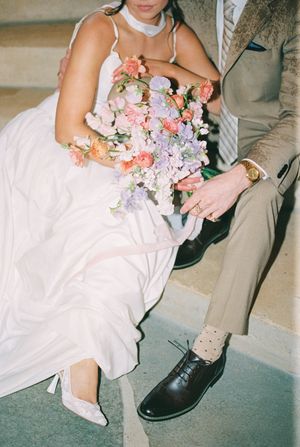 Close-up views of a white wedding dress with pink floral bouquet details against stone steps.