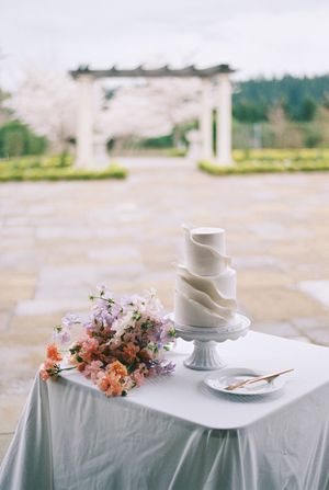 White table settings with delicate floral arrangements and teacups on a light blue tablecloth.