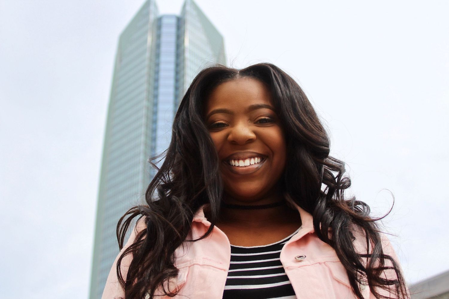 Oklahoma Senior Poses With Devon Tower in Background at the Top of Arts Garage