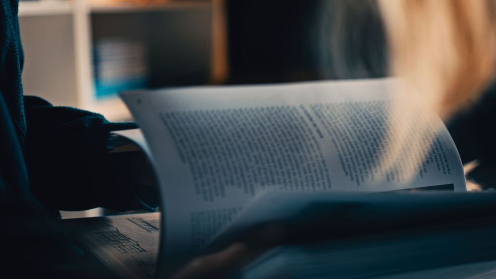 A book page being turned with soft morning light creating a peaceful reading atmosphere.