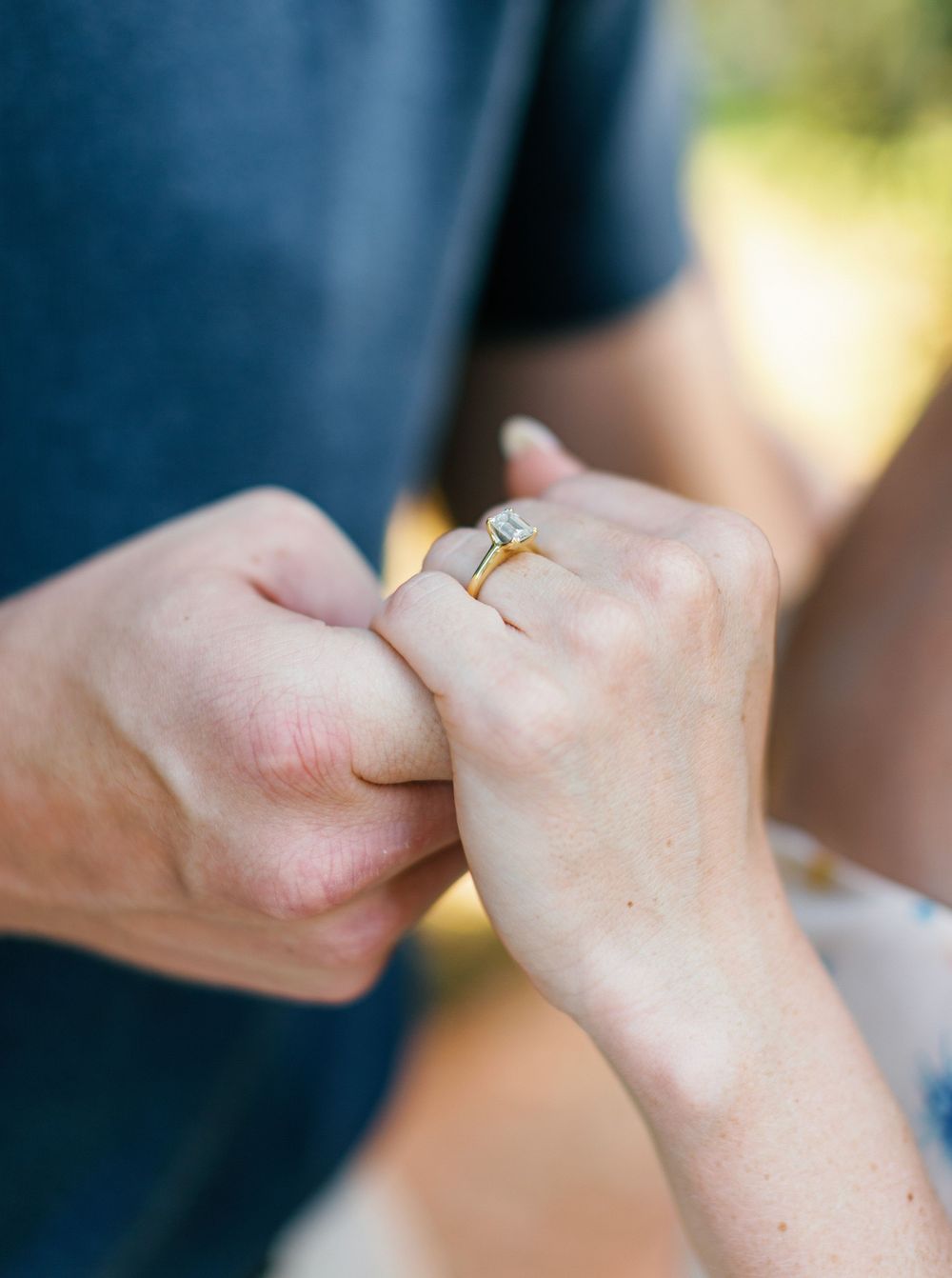 A person's hands showing progressive closeup shots of their ring finger wearing a gold wedding band in sunlight.