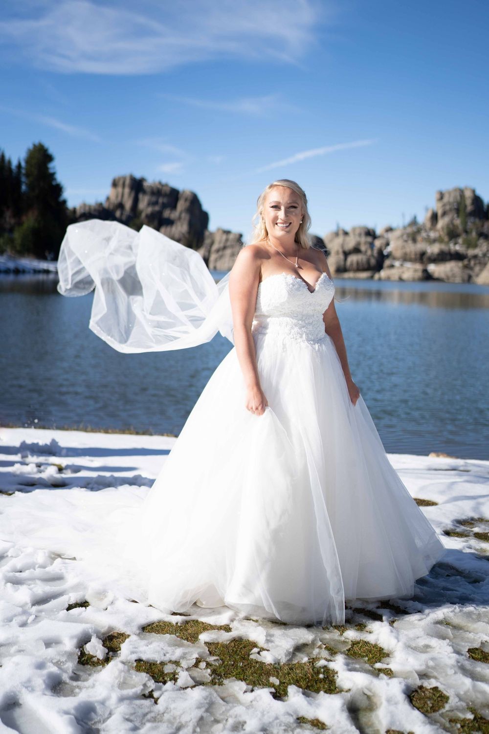 A winter bridal photoshoot series featuring a white wedding dress against snowy terrain and rocky lake landscape.