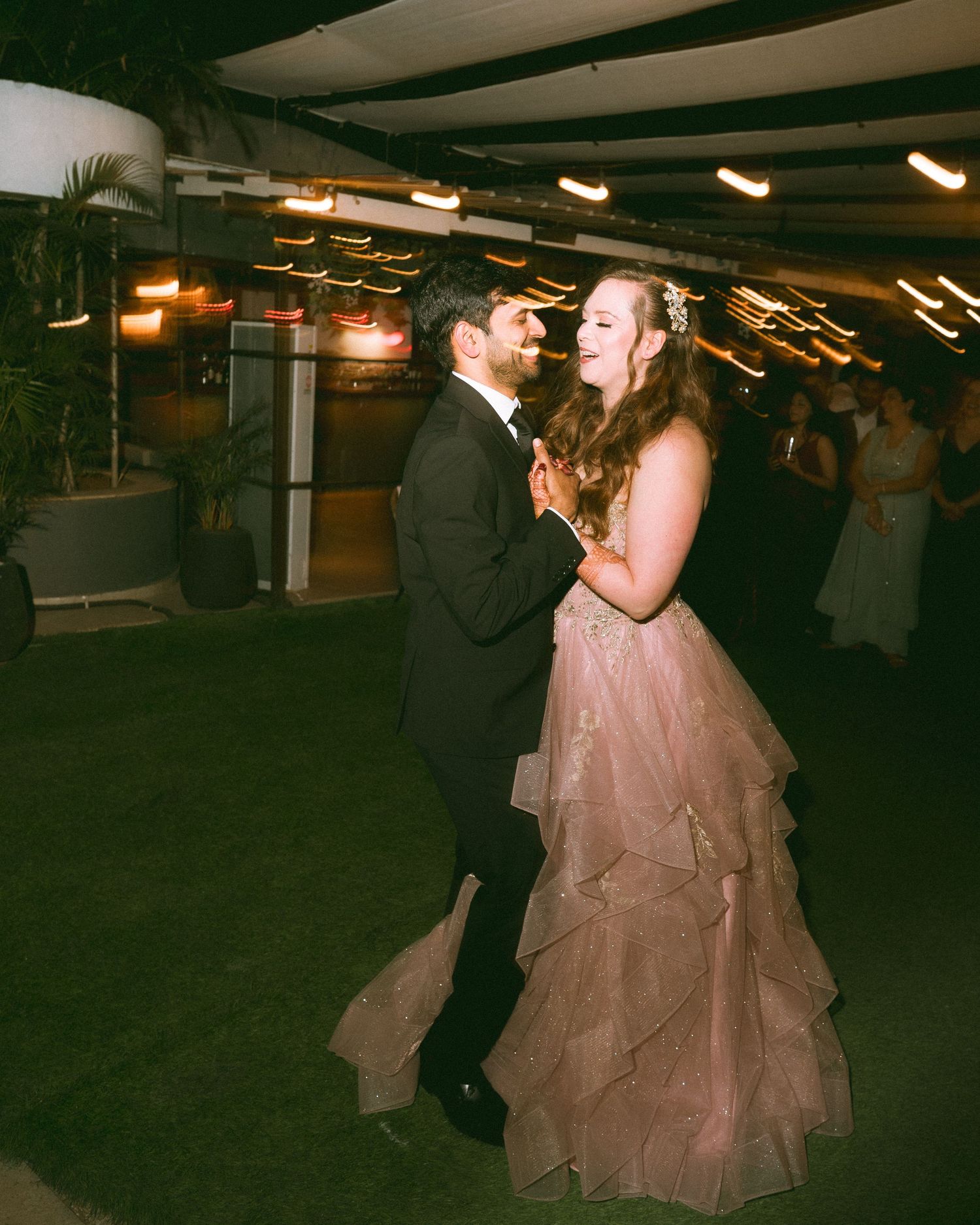 Couple dancing together at their wedding reception under ambient lighting by the best wedding photographer in London & Birmingham.