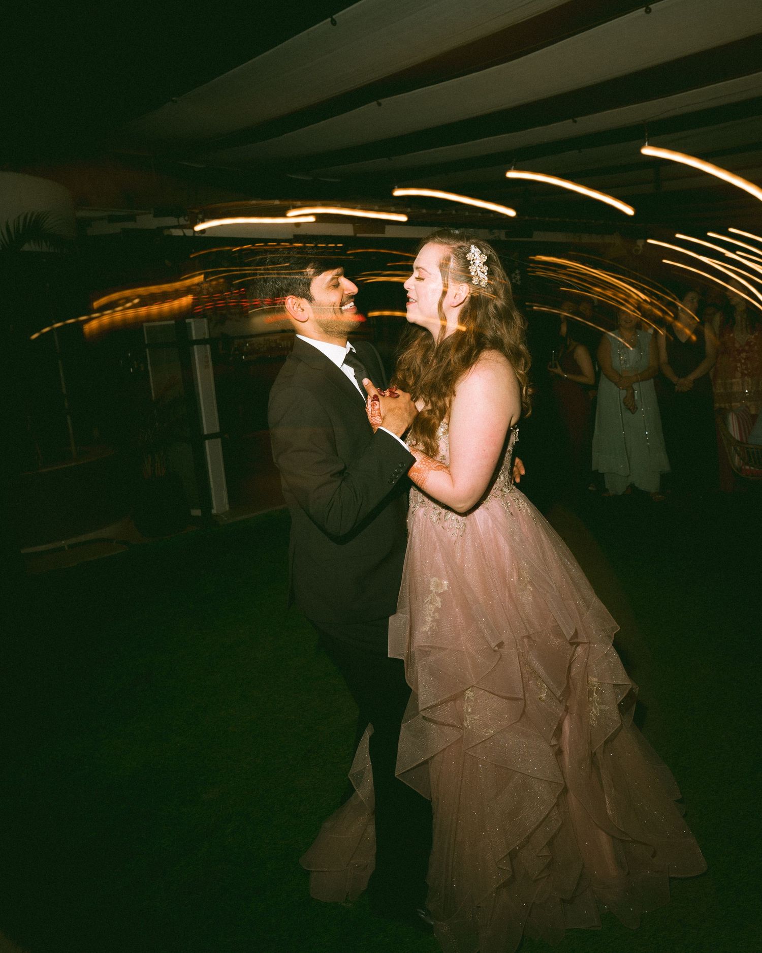 Couple sharing a romantic dance in a dimly lit venue captured by the best wedding photographer in London & Birmingham.