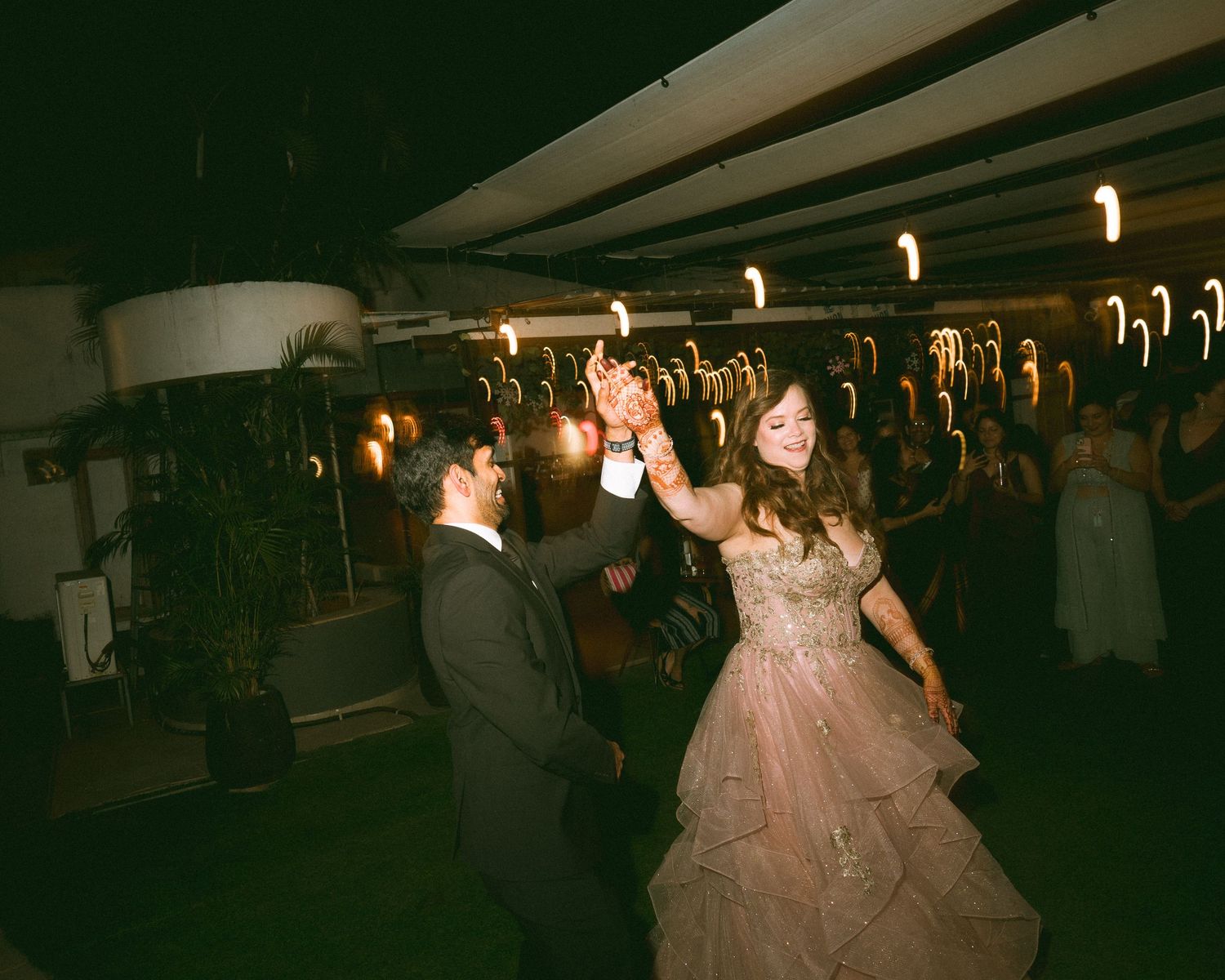 Couple dancing together at a wedding reception under warm lighting by a wedding photographer in London & Birmingham.