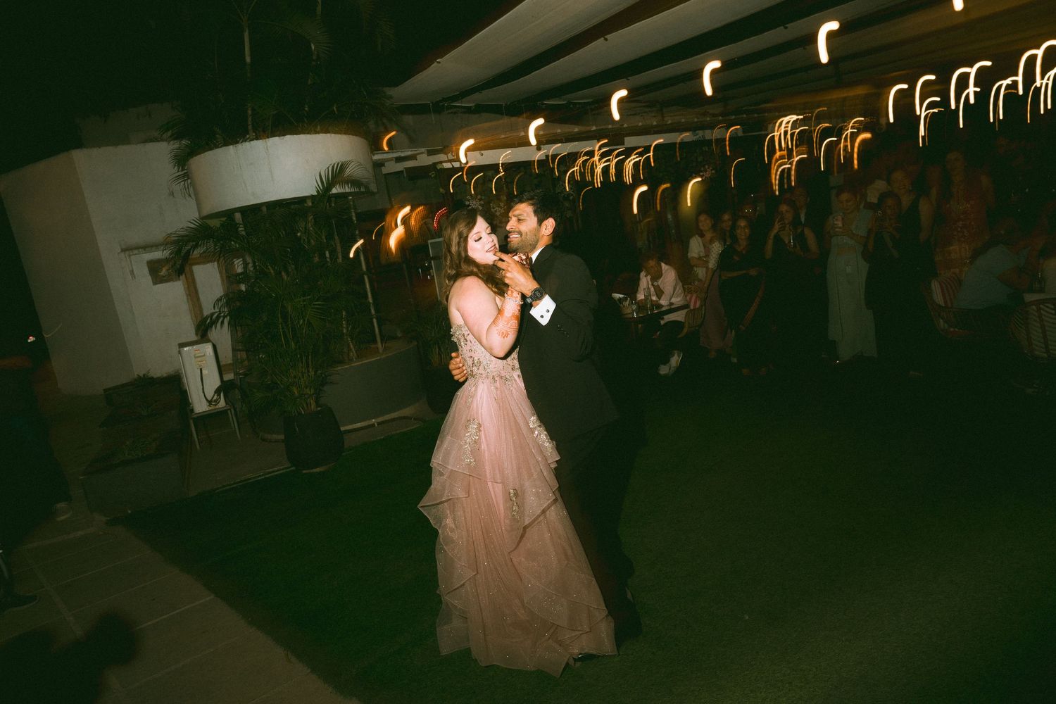 Couple sharing a romantic dance moment in a dimly lit wedding reception venue by a wedding photographer in London & Birmingham.