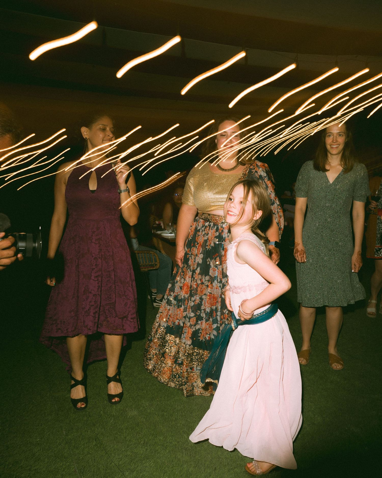 Wedding party guests dancing with light trails streaking across the ceiling by a wedding photographer in London & Birmingham.