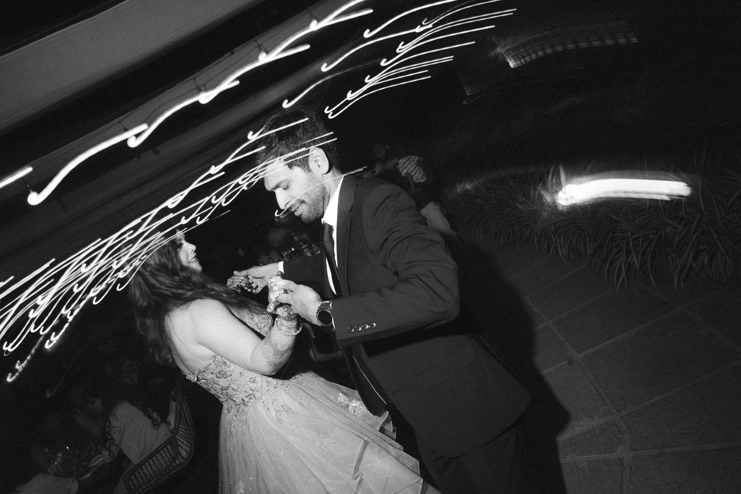 Couple sharing an intimate wedding dance under streaking light trails captured by a wedding photographer in London & Birmingham.