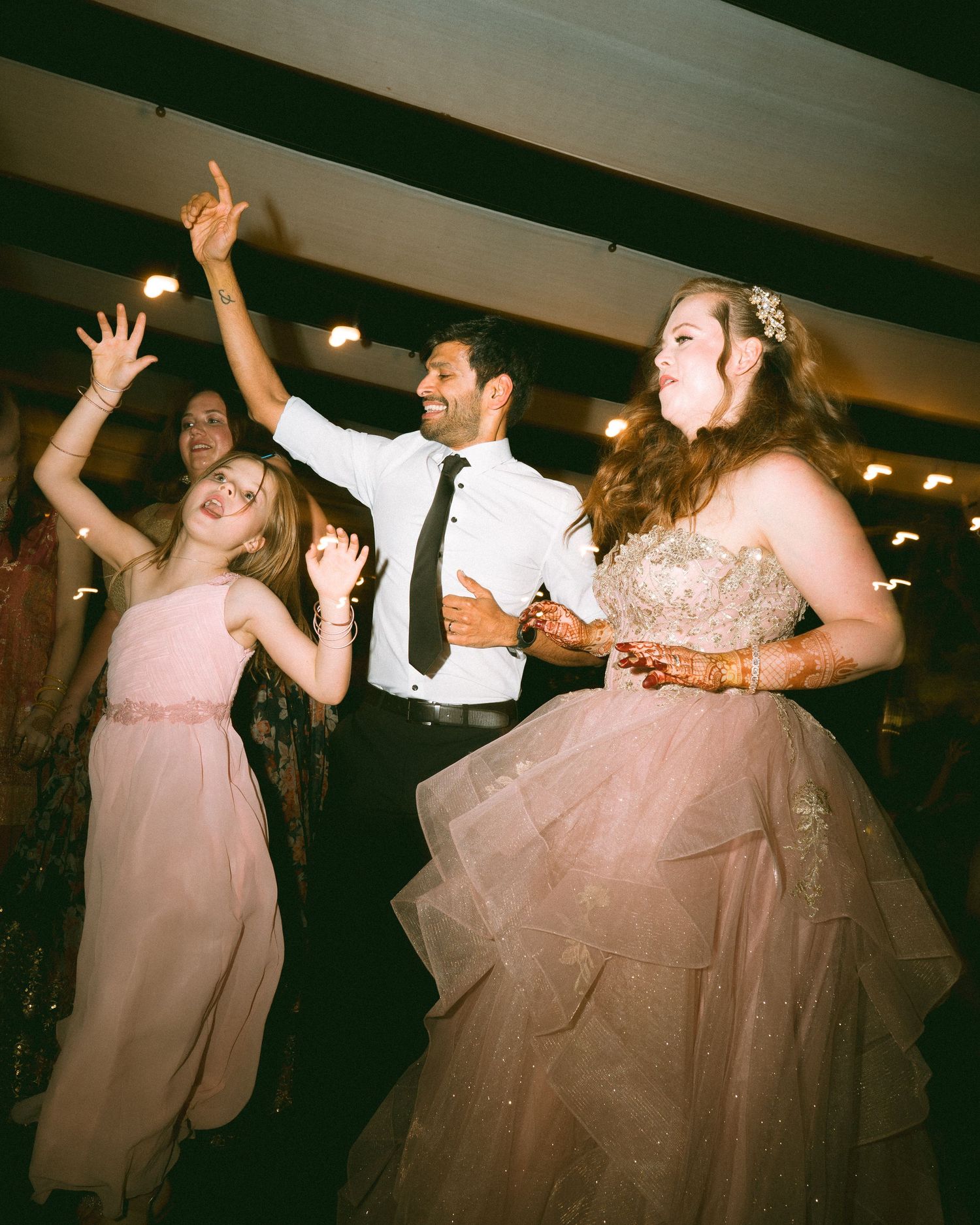 Wedding guests dancing enthusiastically in formal attire captured by a wedding photographer in London & Birmingham.