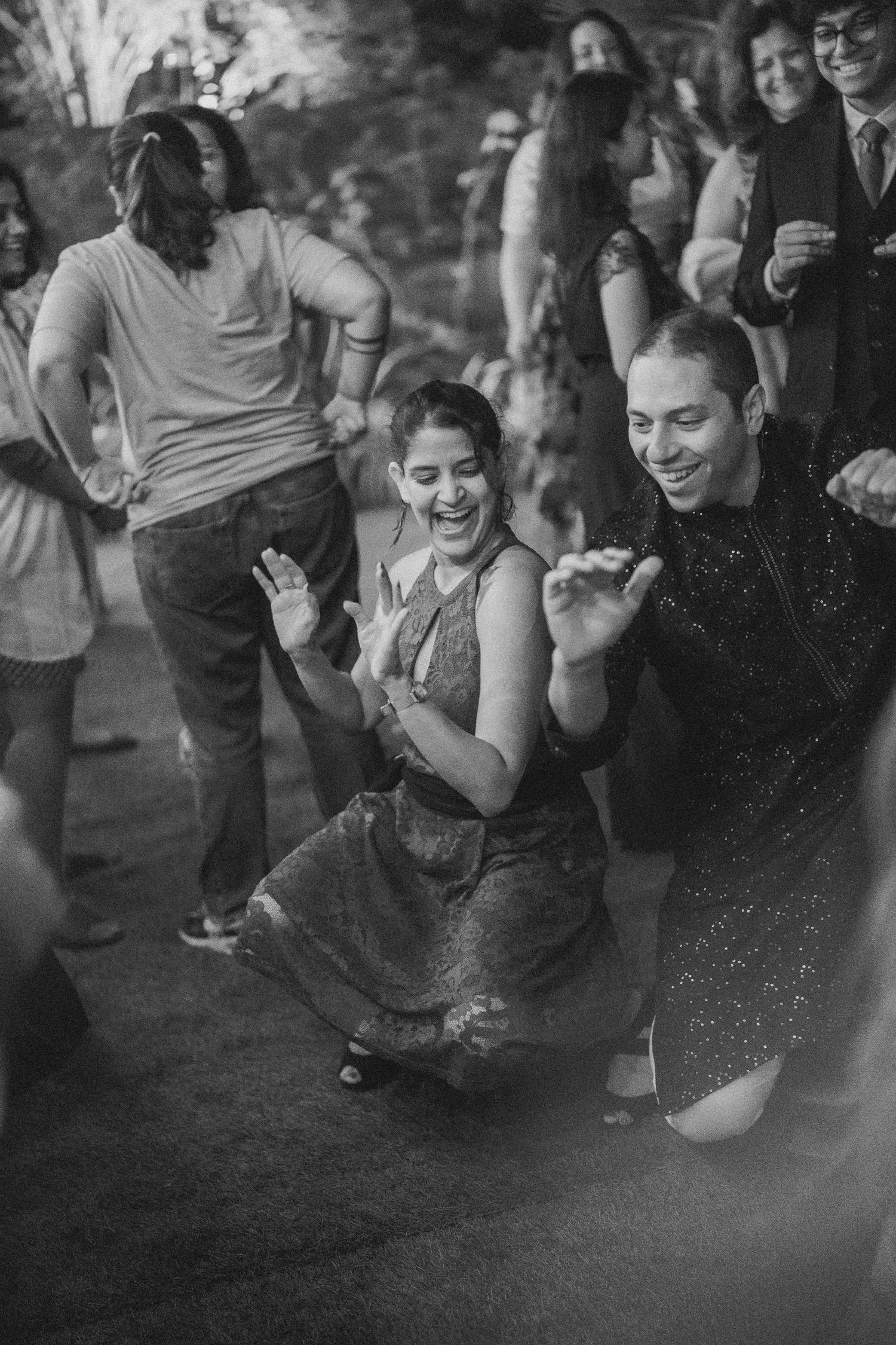 Black & white wedding reception shot of guests dancing and laughing by a wedding photographer in London & Birmingham.