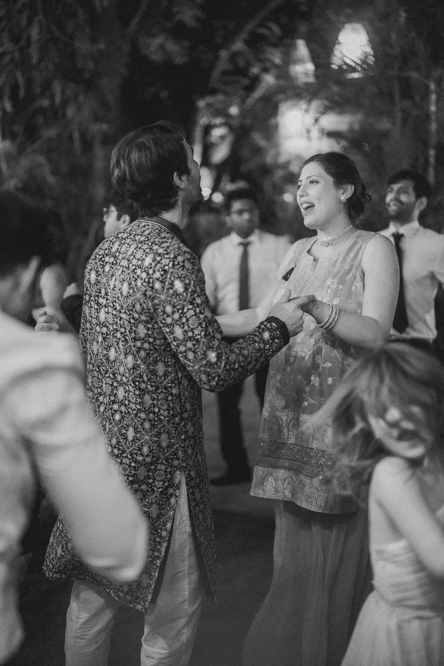 Black & white wedding reception shot of guests dancing and laughing by a wedding photographer in London & Birmingham.