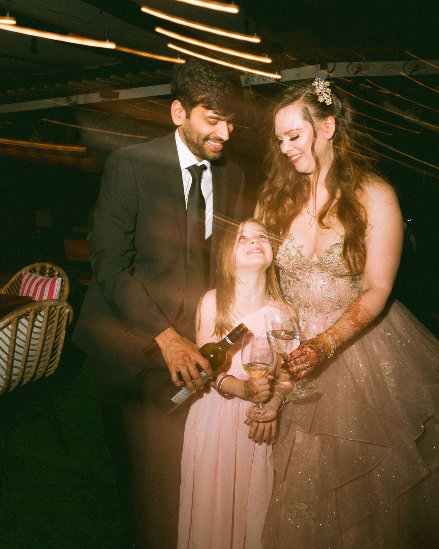 Guests sharing intimate moments at a dimly lit wedding reception under string lights by the best wedding photographer in London