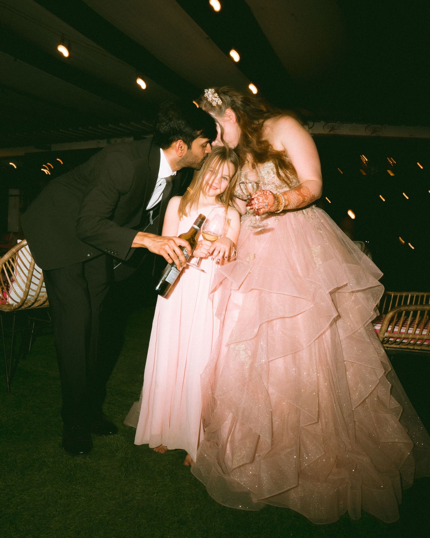 Wedding party members sharing candid moments at an evening celebration with atmospheric lighting by the best wedding photographer in london