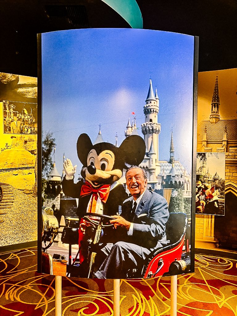 A vintage photo of Mickey Mouse character with Walt Disney at Disneyland Castle against a blue sky backdrop.