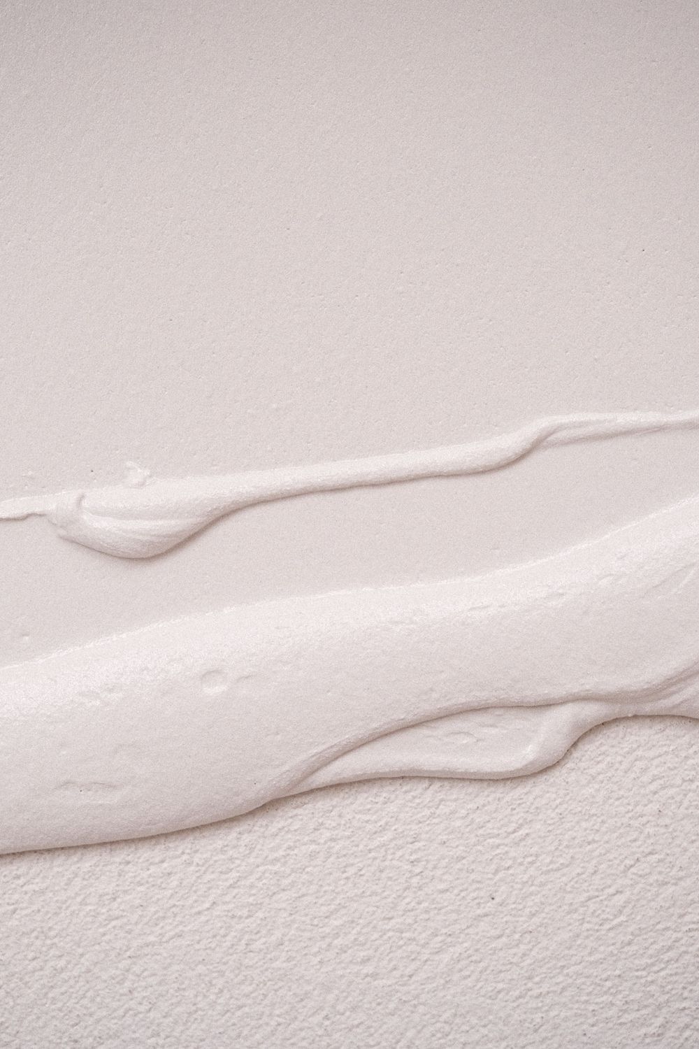 Abstract white textured lines and waves created by plaster or joint compound on a wall.