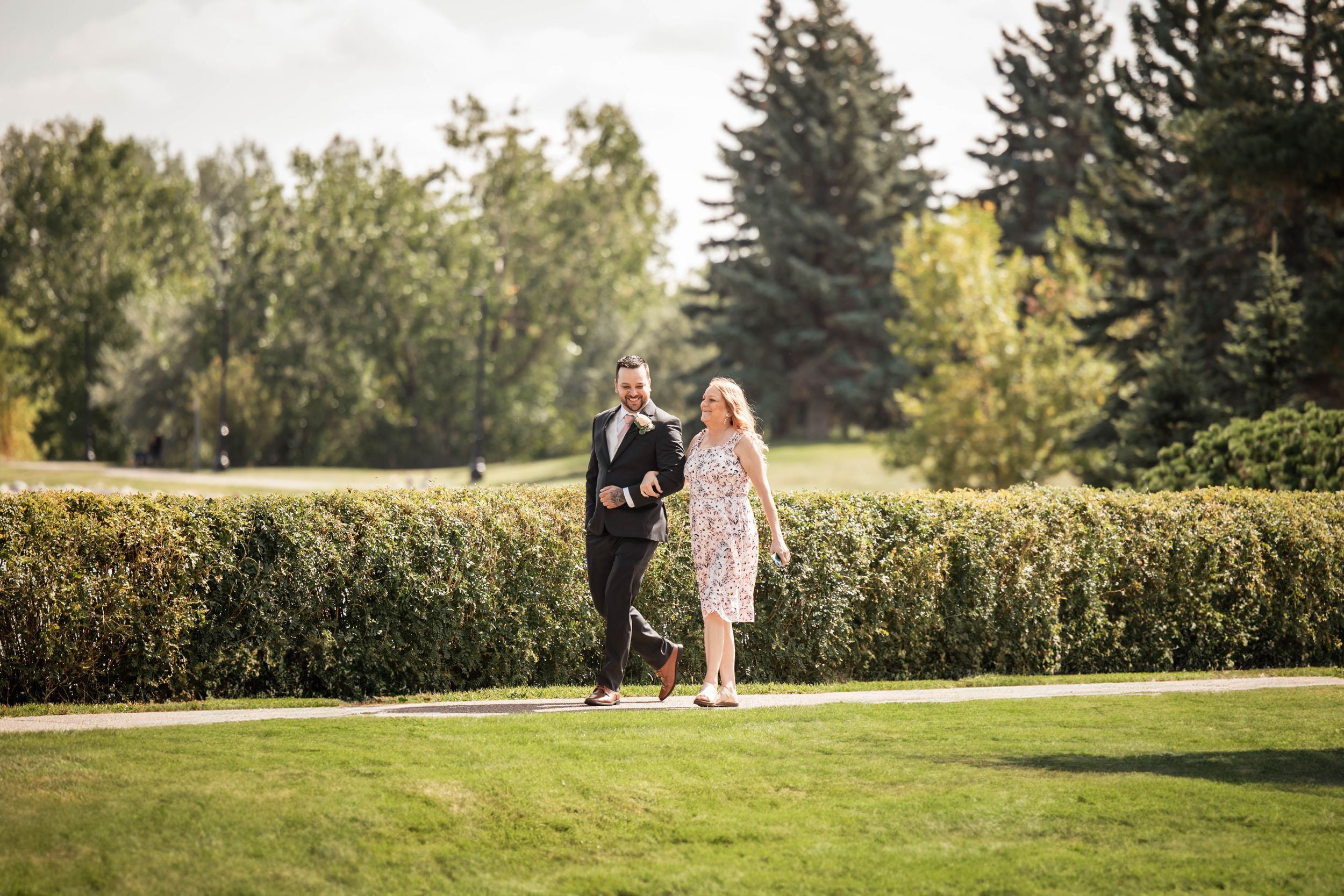 Groom walking down the aisle with his mom