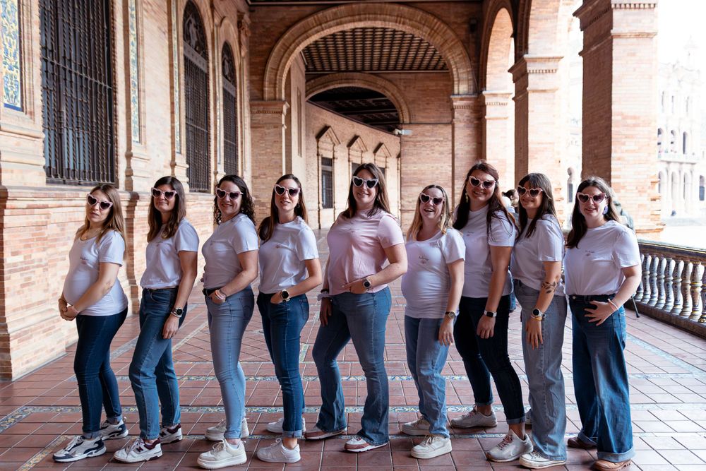 Portraits de groupe EVJF à Séville - Ludivine Mima
Group in matching pink t-shirts and jeans pose together under an ornate archway corridor.
