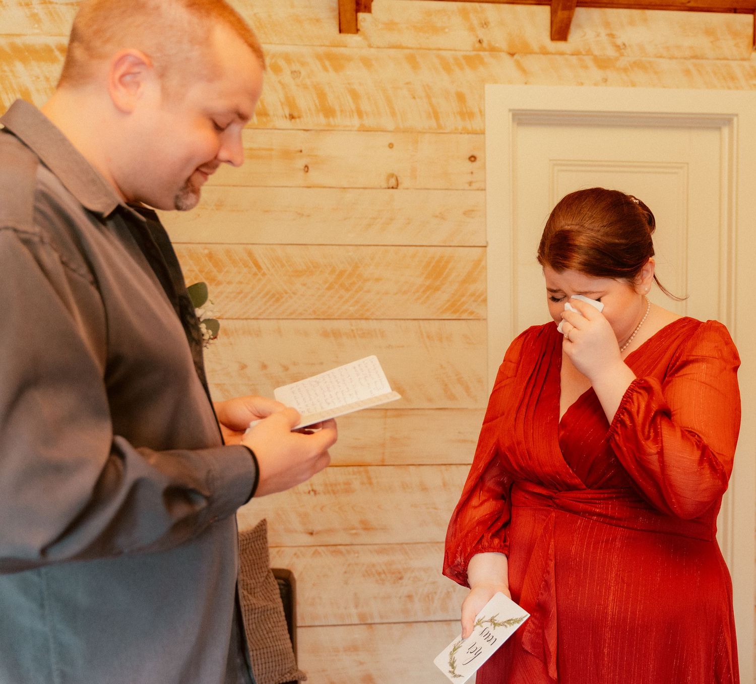 Two people sharing a touching moment while reading letters in a rustic interior.