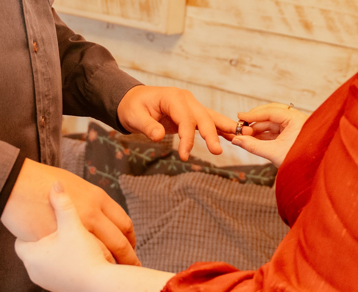 Close-up of hands exchanging rings during an intimate wedding ceremony.