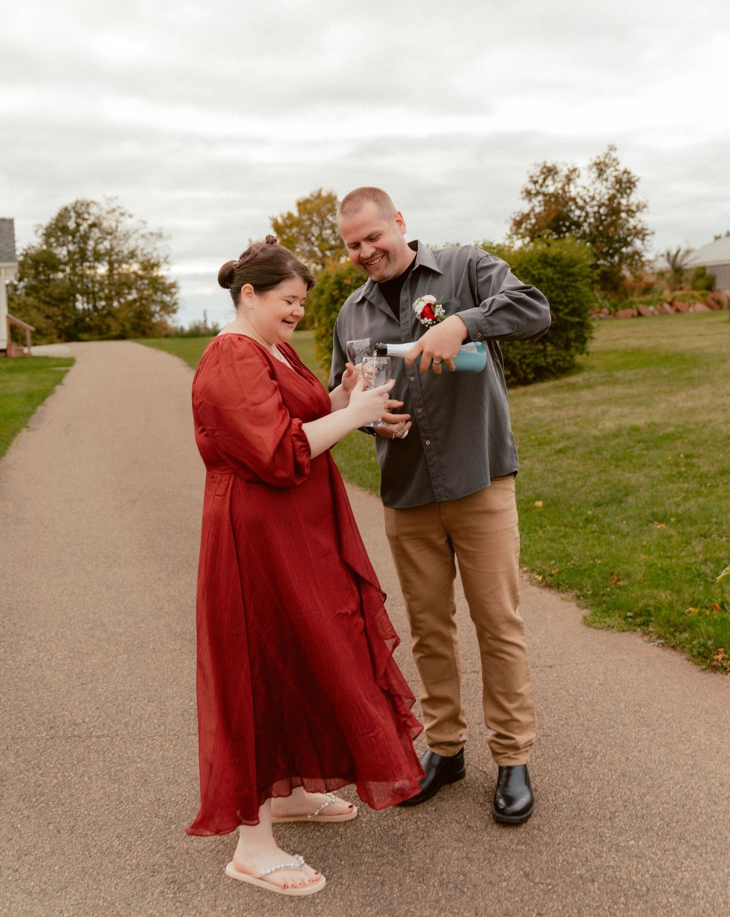 A couple in coordinated outfits shares a moment on a paved outdoor path.