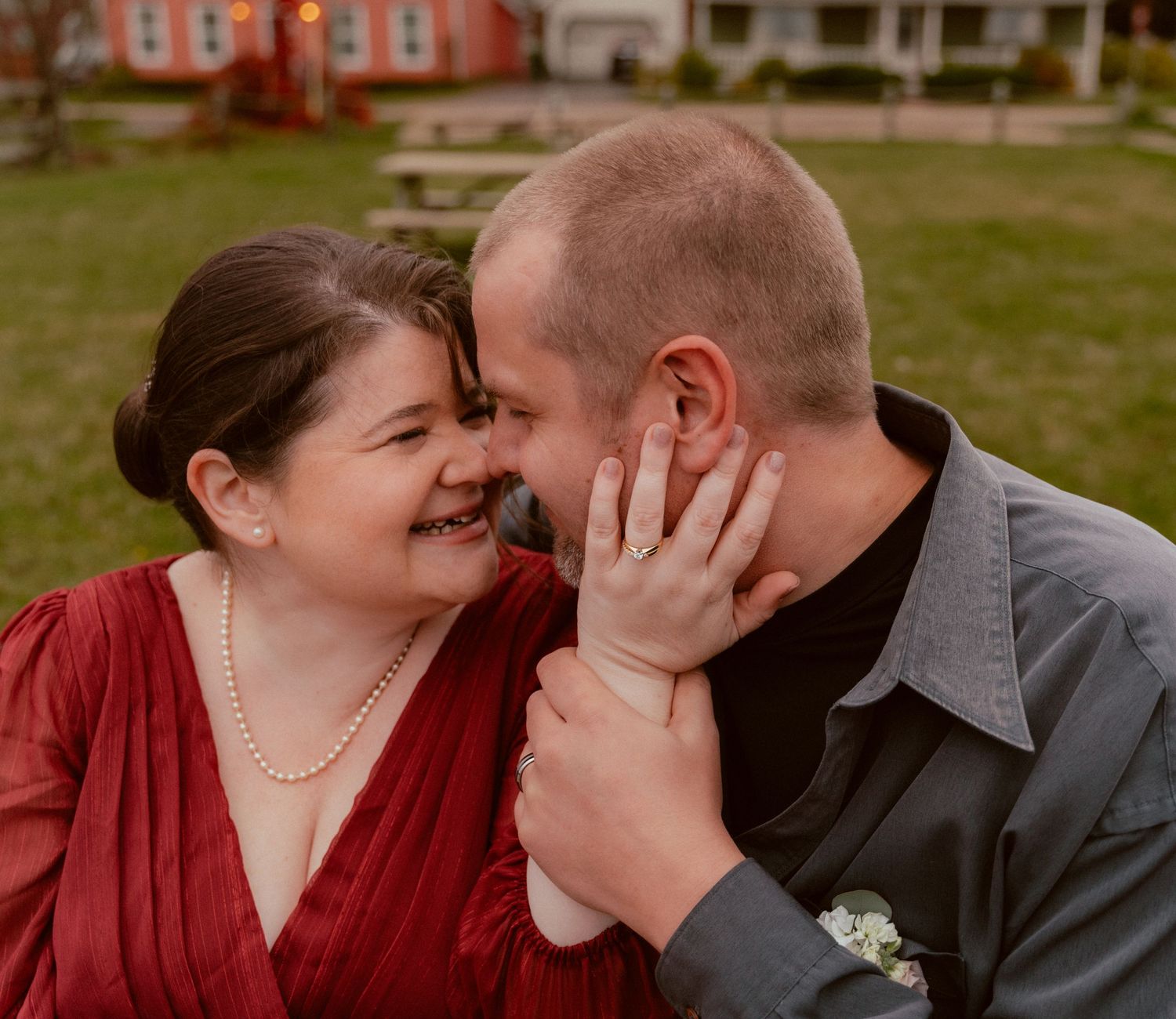 An intimate moment between newlyweds sharing laughter during their wedding portraits.