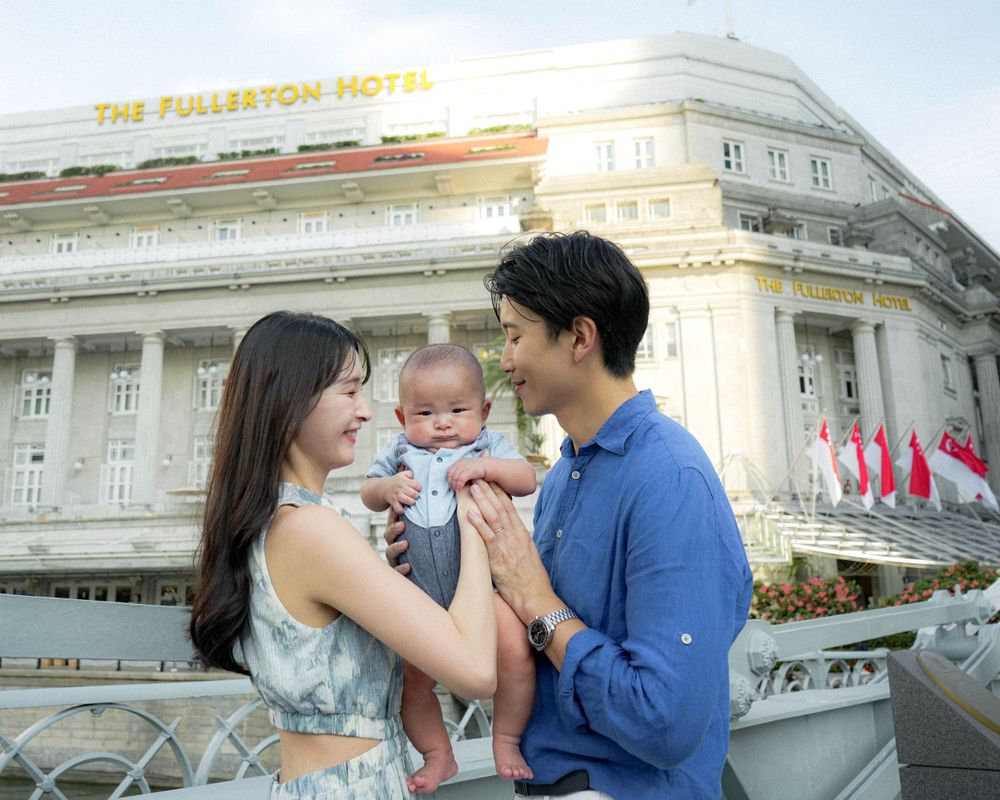 Intimate family portrait against the classic white architecture of Fullerton Hotel.